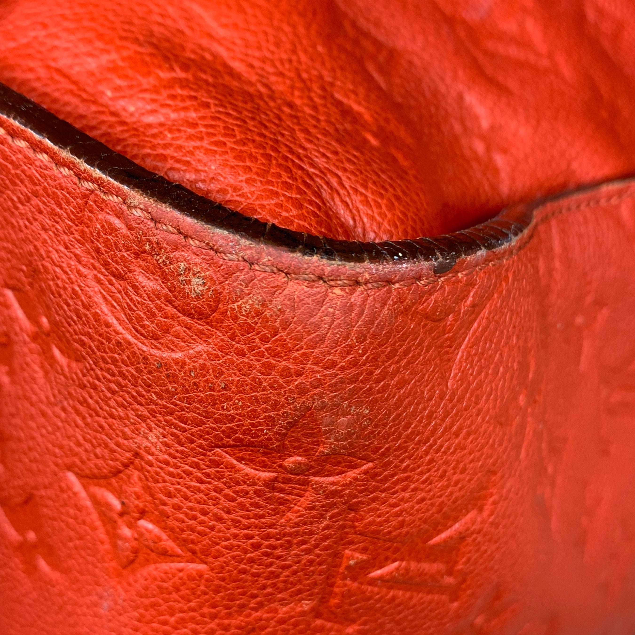 Zoom sur les signes d'usure des coins et les craquelures sur les teintures de tranche du sac Louis Vuitton Lumineuse.